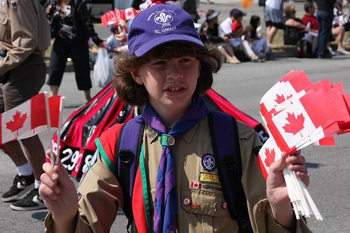 Boyscout holding Canadian flags. Photo.