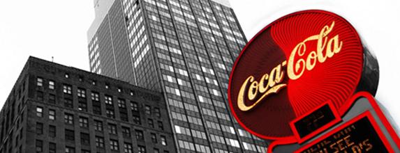 Coca-Cola-skilt framfor ein bygning. Foto.