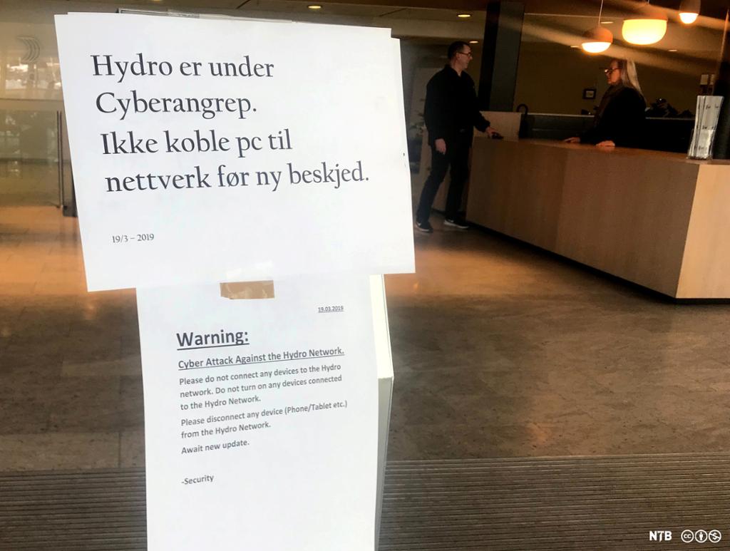 Plakat hengt opp i lobbyen hos Norsk Hydro: "Hydro er under cyberangrep. Ikke koble pc til nettverk før ny beskjed".