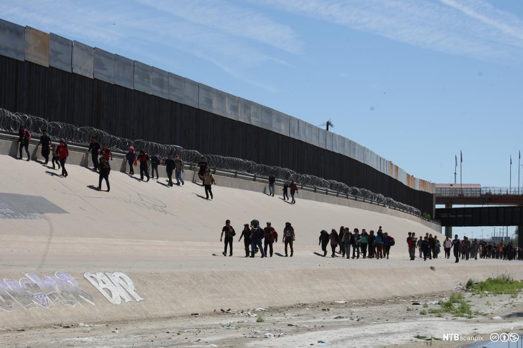 Et fotografi av meksikanske migranter på vei inn i USA.