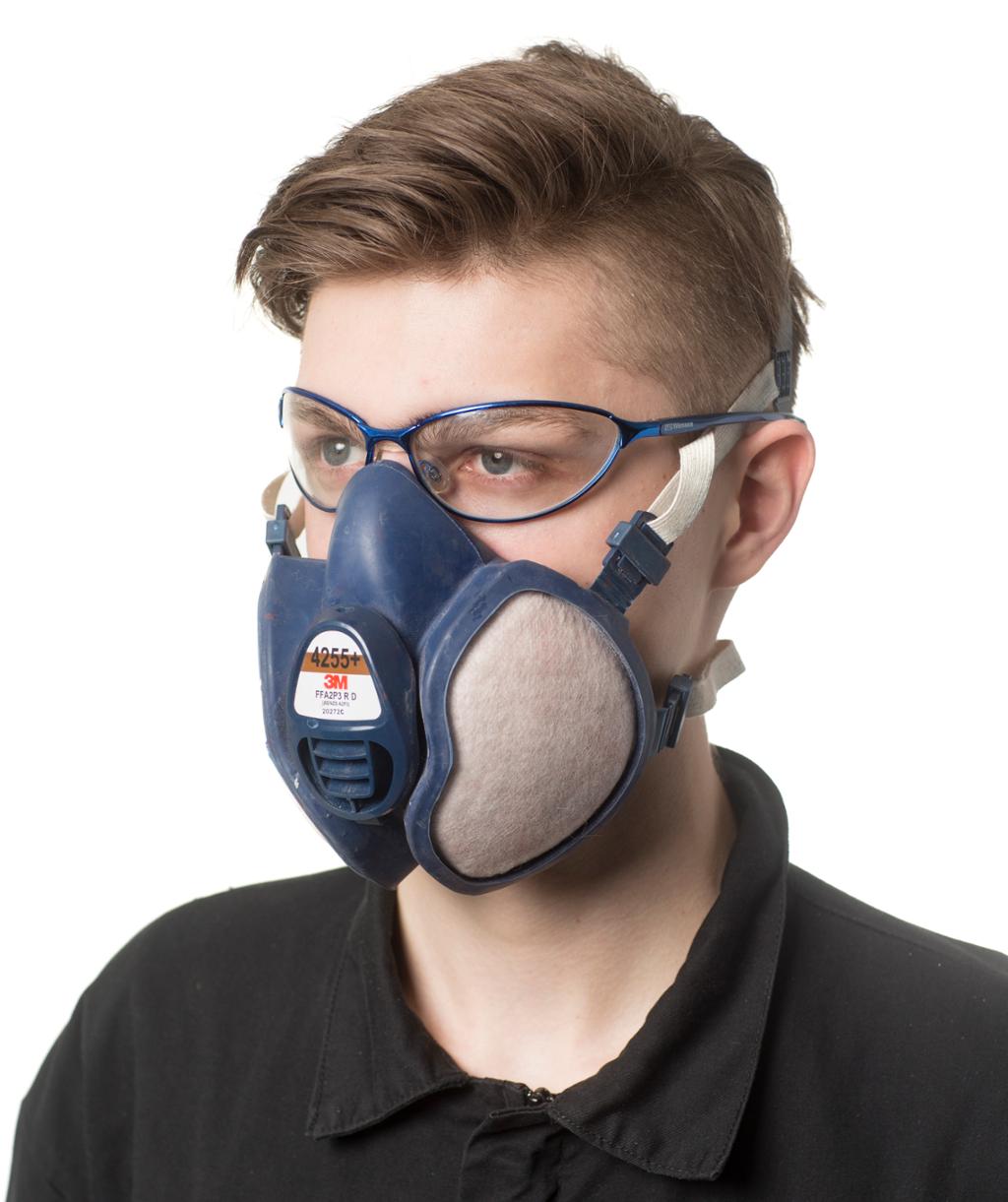 Person med kullfiltermaske foran munnen og vernebriller foran øynene. Foto.