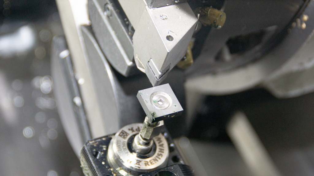 Foto av dreieverktøy i en CNC-maskin som berører en sensor for å lagre verdier om verktøyets størrelse og plassering.
