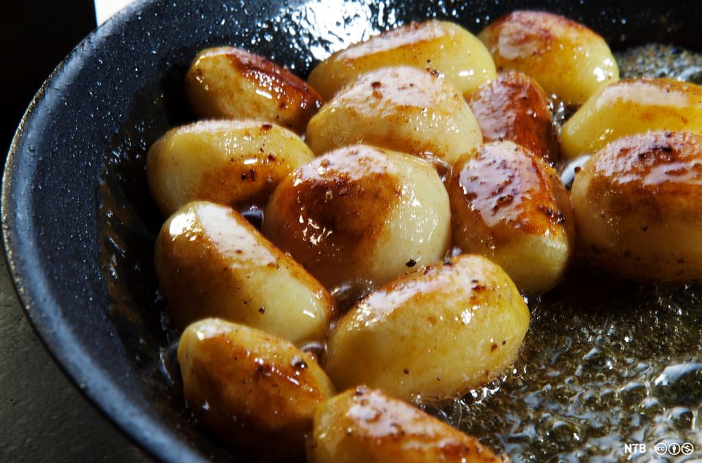 Hele poteter blir steikte gylne i ei steikjepanne. Foto.