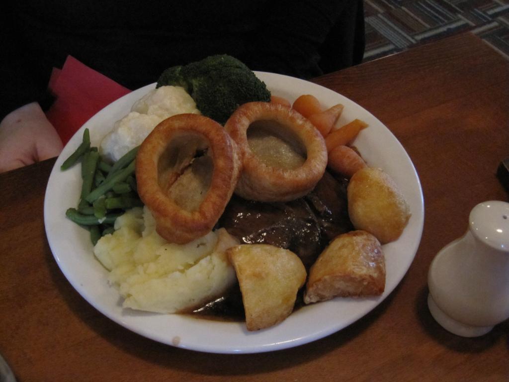 Roast beef med tilbehør på en hvit tallerken. Foto.
