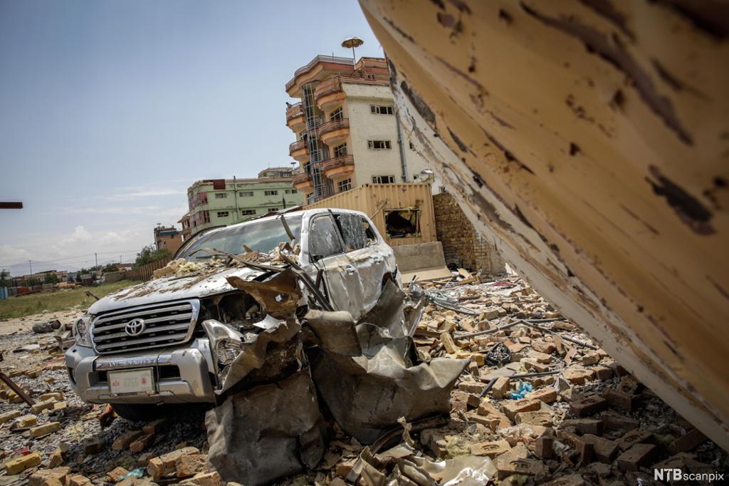 En ødelagt bil, ødelagte bygninger og omgivelser etter selvmordsbombing i Kabul, Afghanistan i 2019. Foto. 