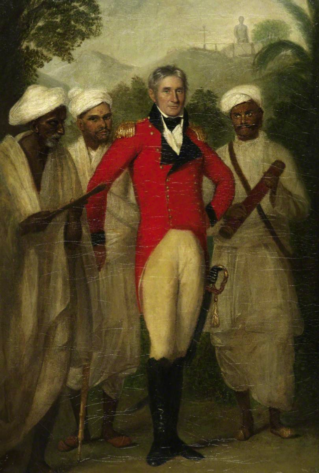 A white man dressed in a red, black and white uniform is standing confidently in front of three Indian servants dressed in all white clothes. Painting.