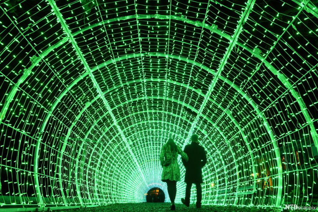 To mennesker går gjennom en tunnel med LED-lamper.
