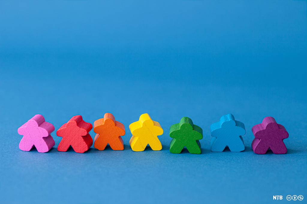 Små trefigurer  av mennesker i regnbuefarger. Foto