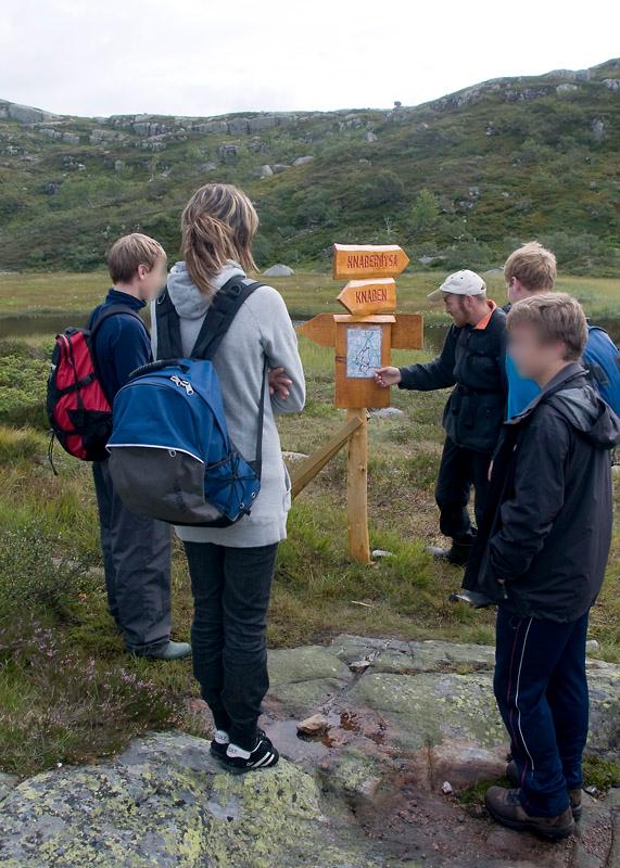 Elever er samlet rundt kartoppslag på fjellet. Foto