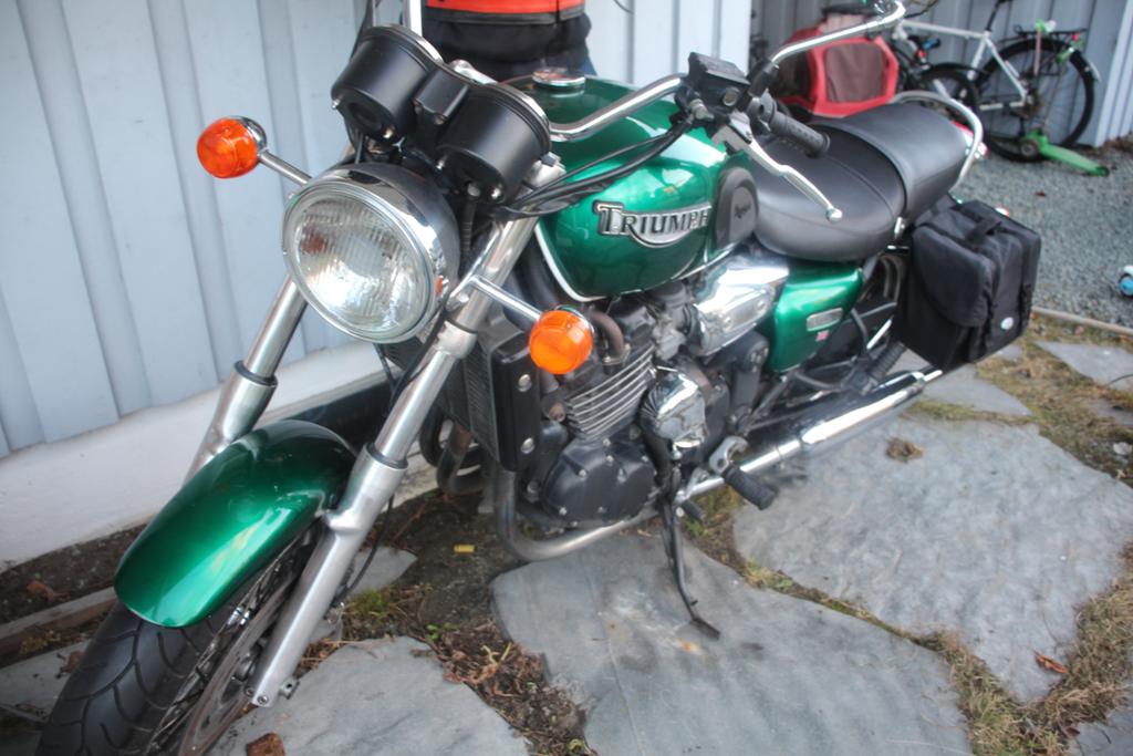 Foto av ein grøn motorsykkel med ein klassisk utsjånad. På sida står det "Triumph".