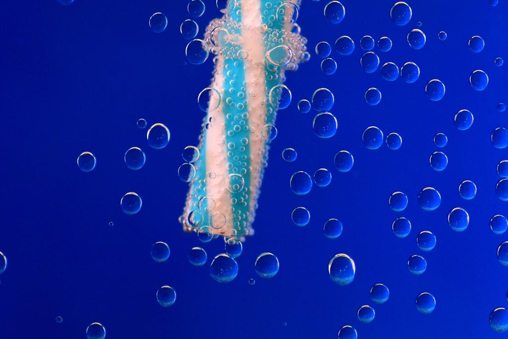 Nærbilde av sugerør og luftbobler i vann. Foto.