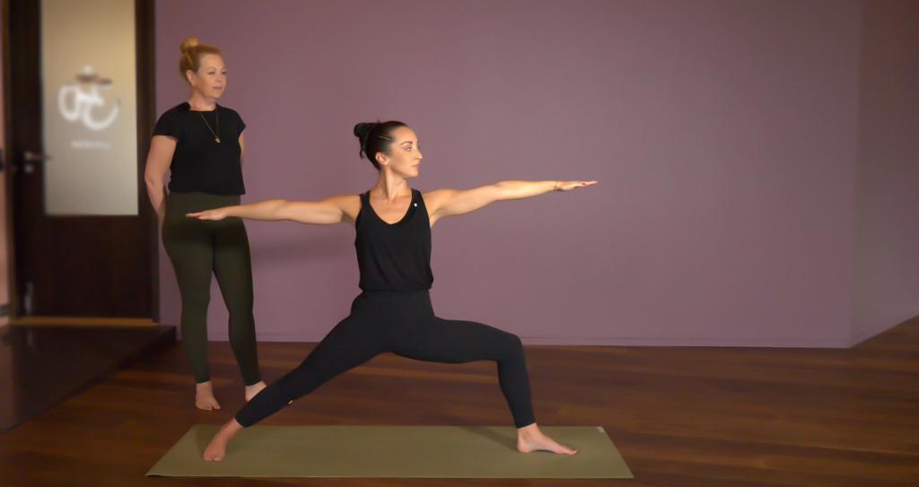 Dame på yogamatte som gjør yogaøvelsen "krigerstilling 2". Foto.