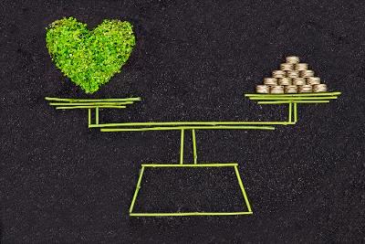 Illustrasjon av en vektskål med et grønt hjerte på den ene vekten og penger på den andre.