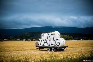 Rundballer som ligger på en henger. Det står "matvalg" på ballene. Foto. 
