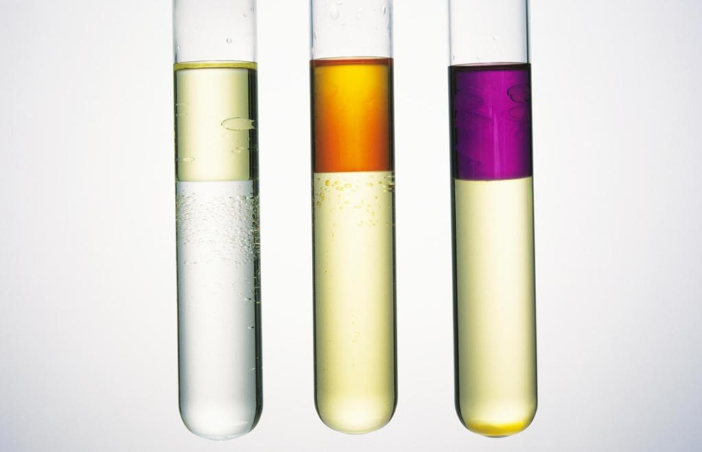 Tre reagensrøyr med løysningar i ulike fargar som blandar seg. Foto.