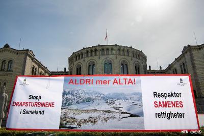 Banner med slagord mot vindmølleutbygging i Sameland. Stortinget i bakgrunnen. Foto.