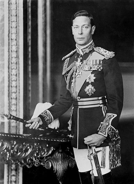 A photo showing King George VI. He's posing in a uniform with medals and orders, holding a sceptre. 