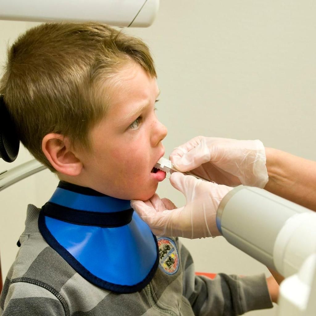 Eit barn tek røntgenbilete hos tannlegen. Foto.