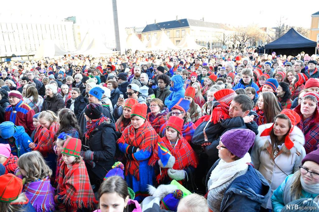 Ei stor folkemengde, mellom anna med mange personar i ulike samiske kufter, på torget i Trondheim. Lavvoar er sette opp i bakgrunnen. Foto.