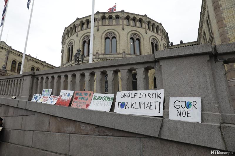 Plakatar med parolar for klimaet sette opp framfor Stortinget. Foto.