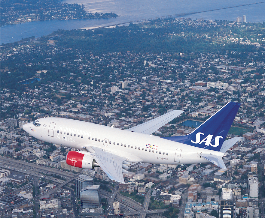 SAS flyg over bebyggelsen i ein by.foto.