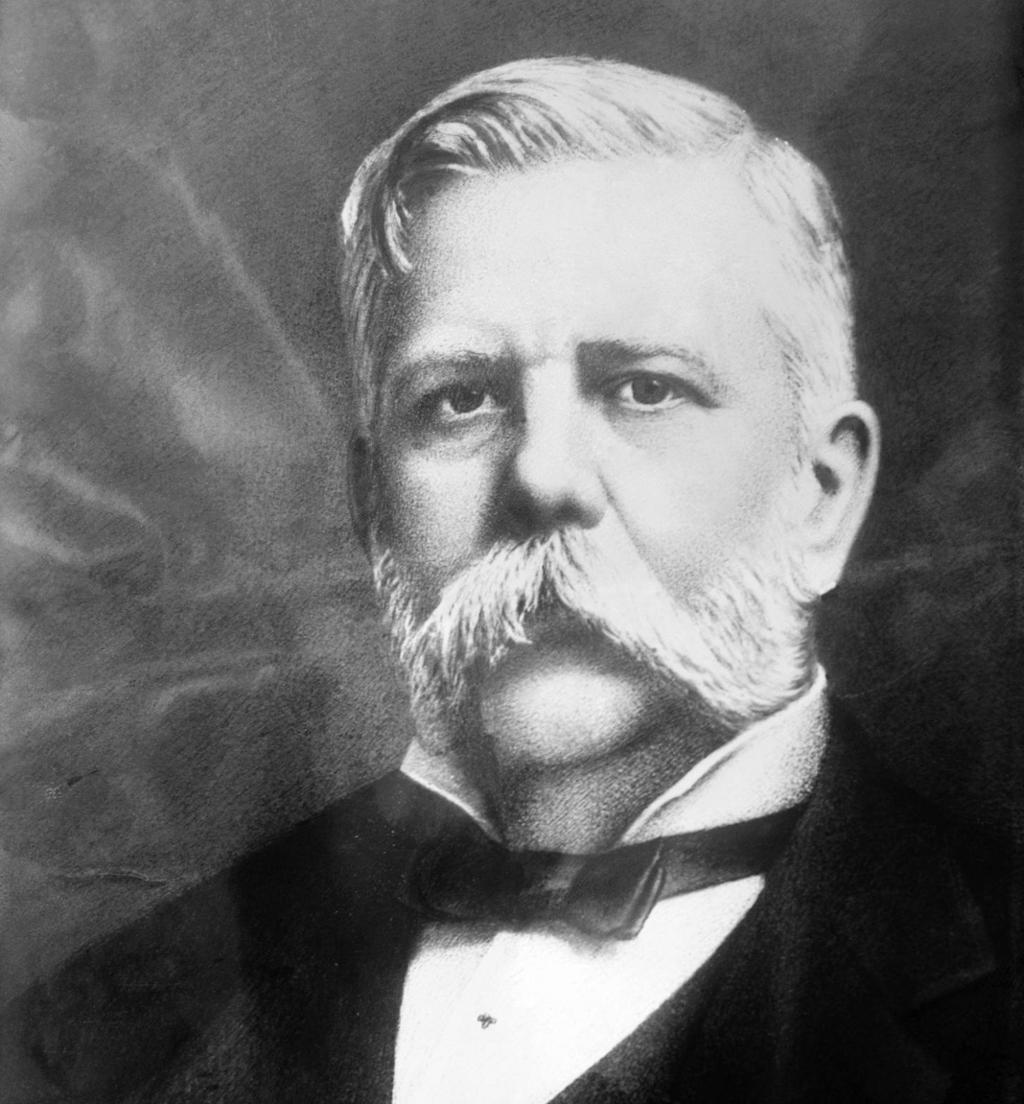 Photo: Portrait of George Westinghouse. We see a man with white hair, sideburns and a large moustache. He is wearing a dark suit, white shirt and a bow tie. 