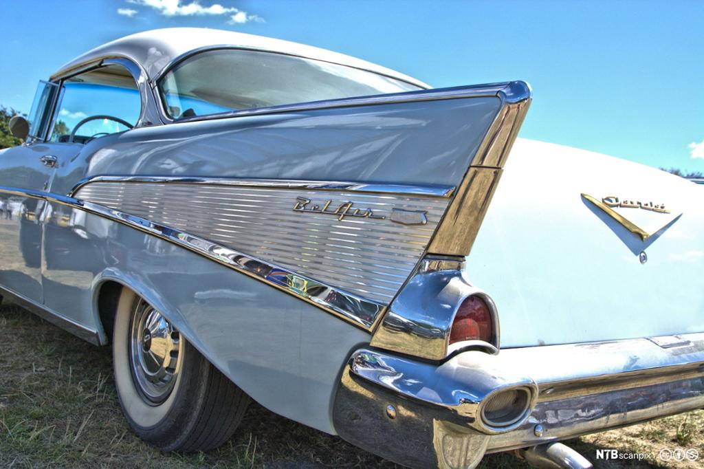 Detalj av halefinne på en lyseblå Chevrolet Bel Air. Her er det maling, blankt metall og matt metall. Foto.