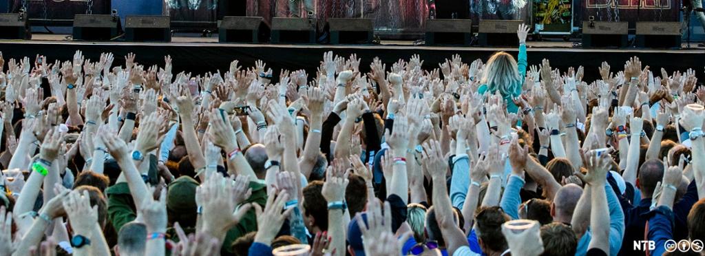 Publikum står med hendene i været foran scenen mens Volbeat spiller på Tons of Rock på Ekeberg. Foto.
