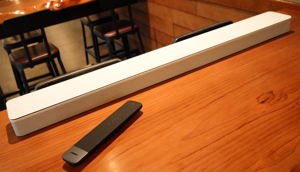 En lang, smal og hvit lydplanke på et bord. Foto.