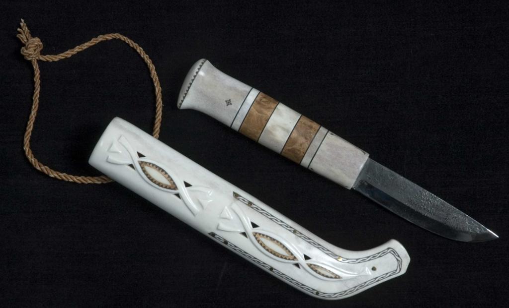 Kniv med skaft av reinhorn og tre, slire av reinhorn, tvinna lærreim. Foto.