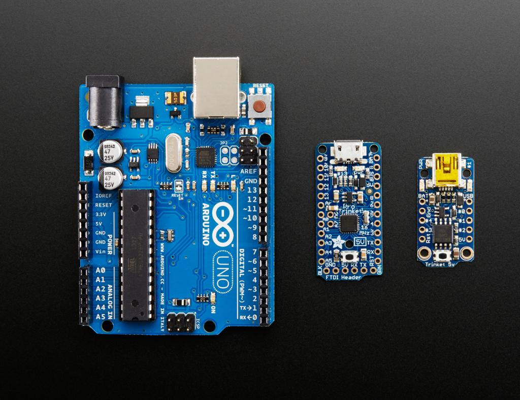 Tre ulike modellar av mikrokontrollerar, med Arduino Uno, Adafruit Trinket og Adafruit Pro Trinket. Foto.