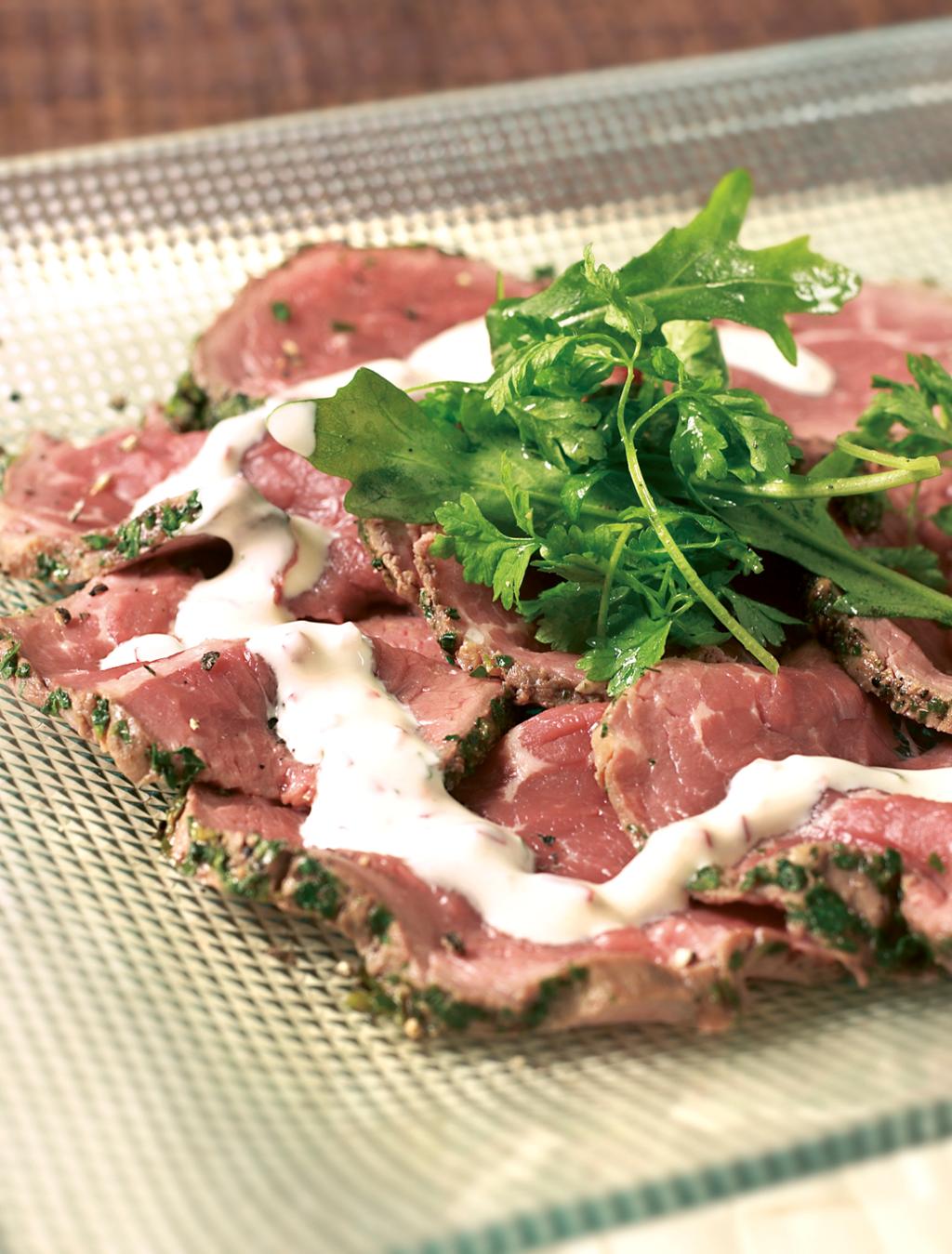 Carpaccio med garnityr på et blankt fat. foto.