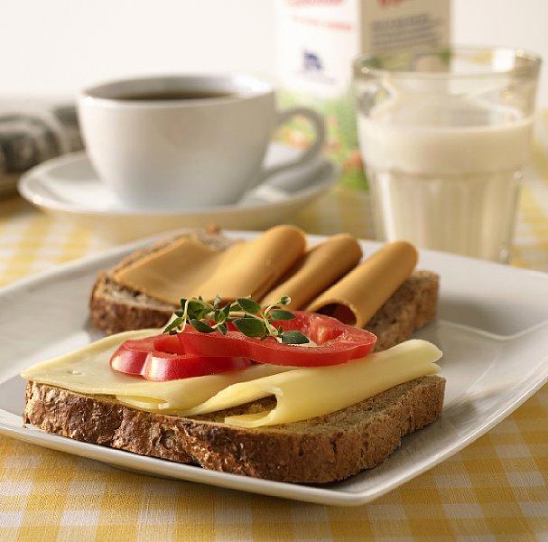 Frokost bestående av to brødskiver, melk og kaffe. Foto.