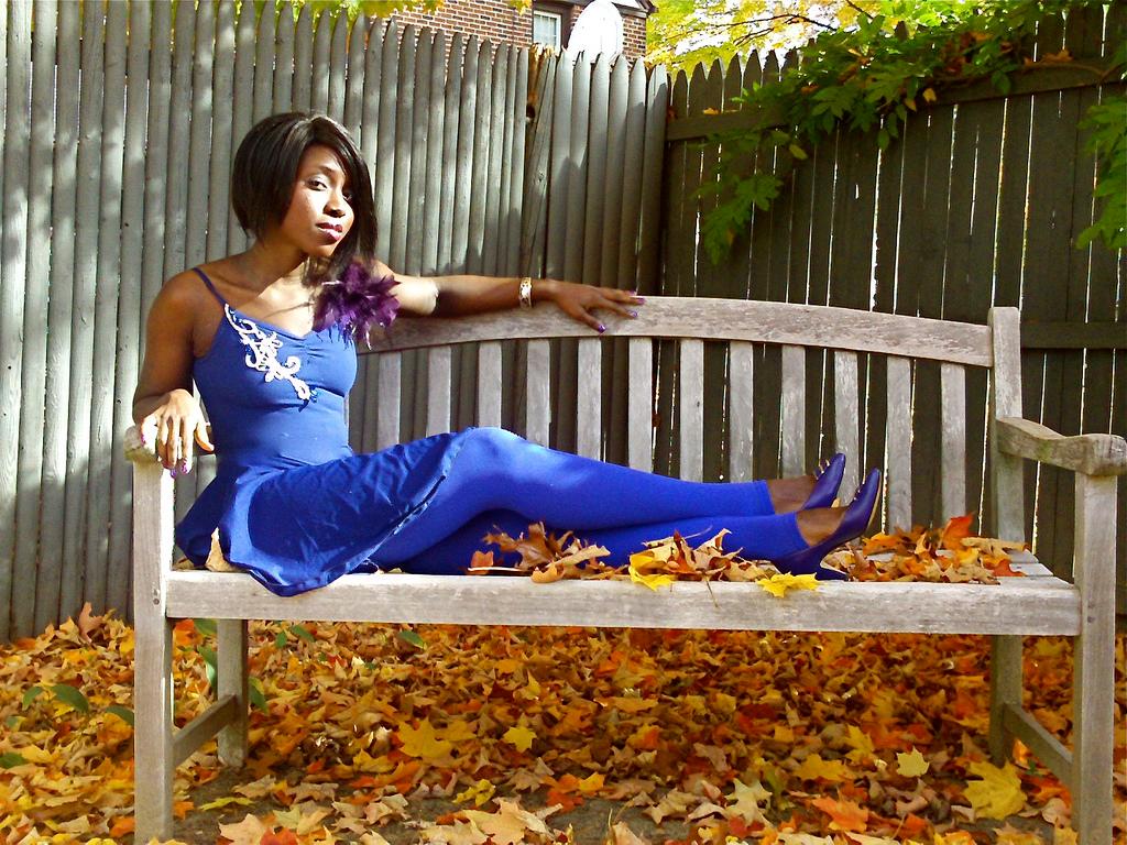 Southern girl in dress lying on a bench. Photo.
