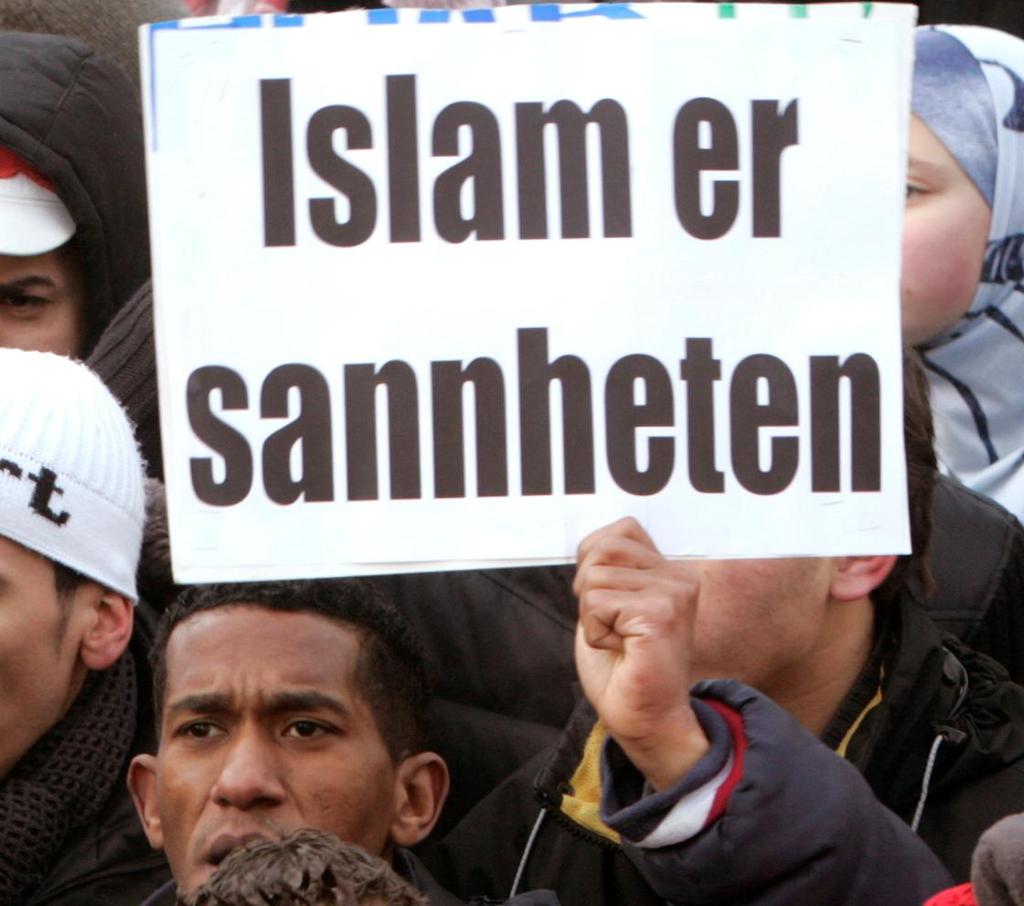 Ei gruppe unge menn held opp ein plakat med teksten: "Islam er sannheten". Foto.