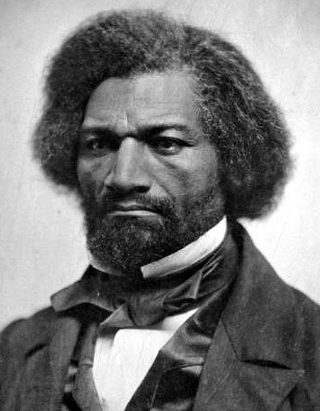 A black and white photo of Fredrick Douglass. He is a Black man dressed in a suit and a bow. He has thick hair and a beard. His expression is sad, or even angry.