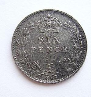 A photo of a British sixpence from 1897. The head of Queen Victoria is on one side of the coin. 