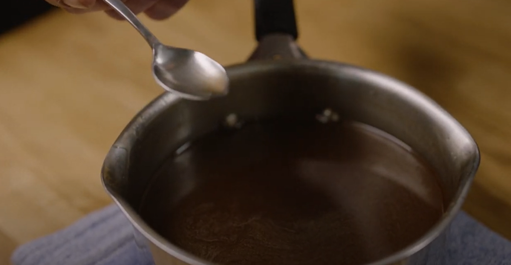 En liten kasserolle med innkokt umami-kraft. Skjermdump fra filmen Vegansk kraft og saus. Foto.