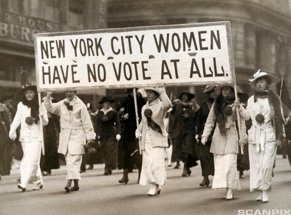Women dressed in white demonstrating for the right to vote. Photo.  