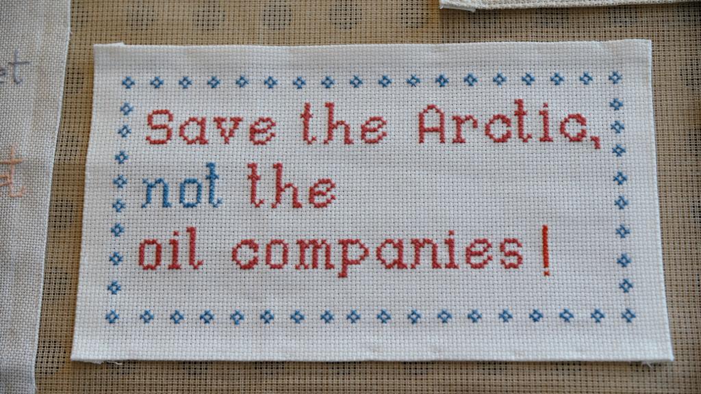 Broderi med teksten: "Save the Arctic, not the oil companies!". Foto.