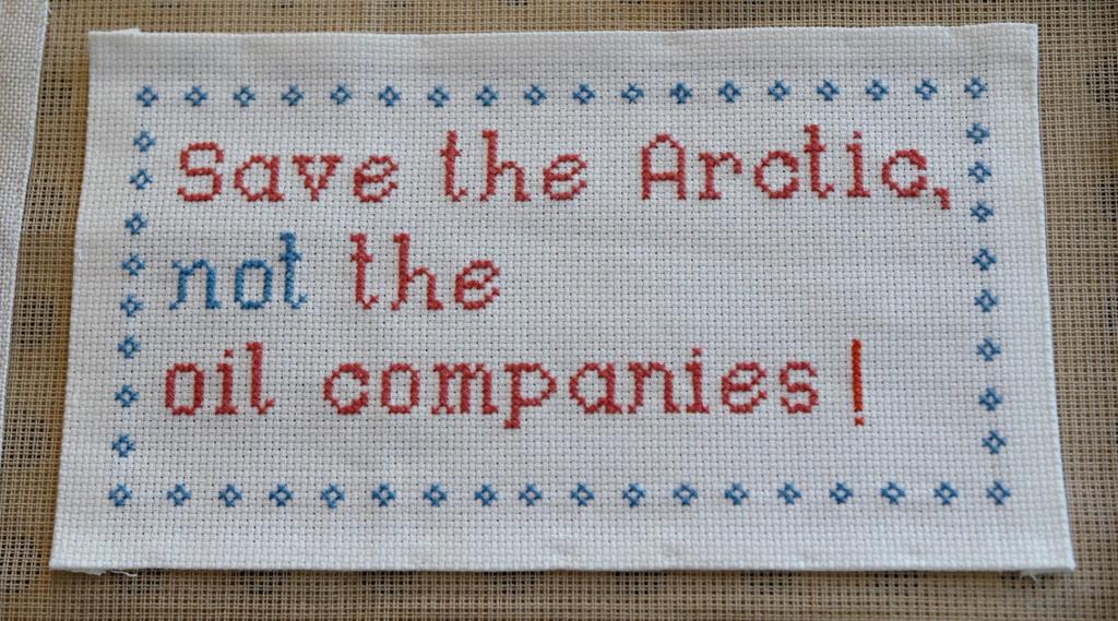 Broderi med teksten: "Save the Artic, not the oil companies!". Foto.