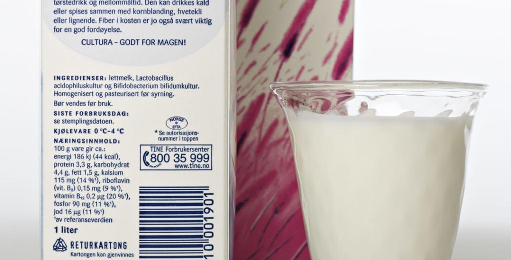 Nærbilde av et glass melk ved siden av to melkekartonger. Foto.