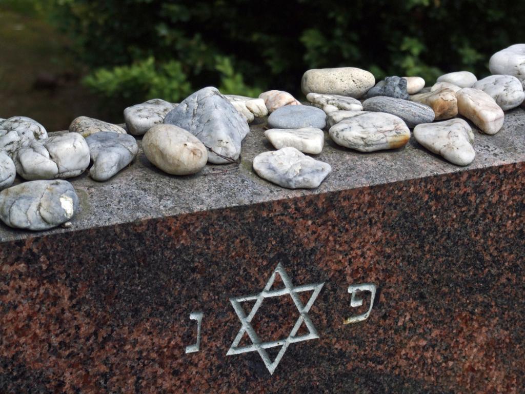 Jødisk gravstein med Davidstjerne. På gravsteinen ligger det små steiner. Foto.