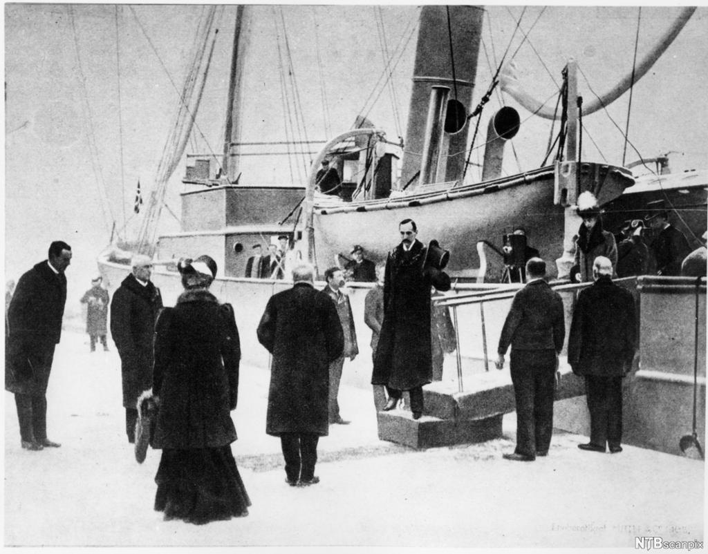 I 1905 kjem Kong Haakon VII til Noreg med skipet Heimdal, som norsk konge, og blir tatt imot på kaien av norske politikarar. Foto.