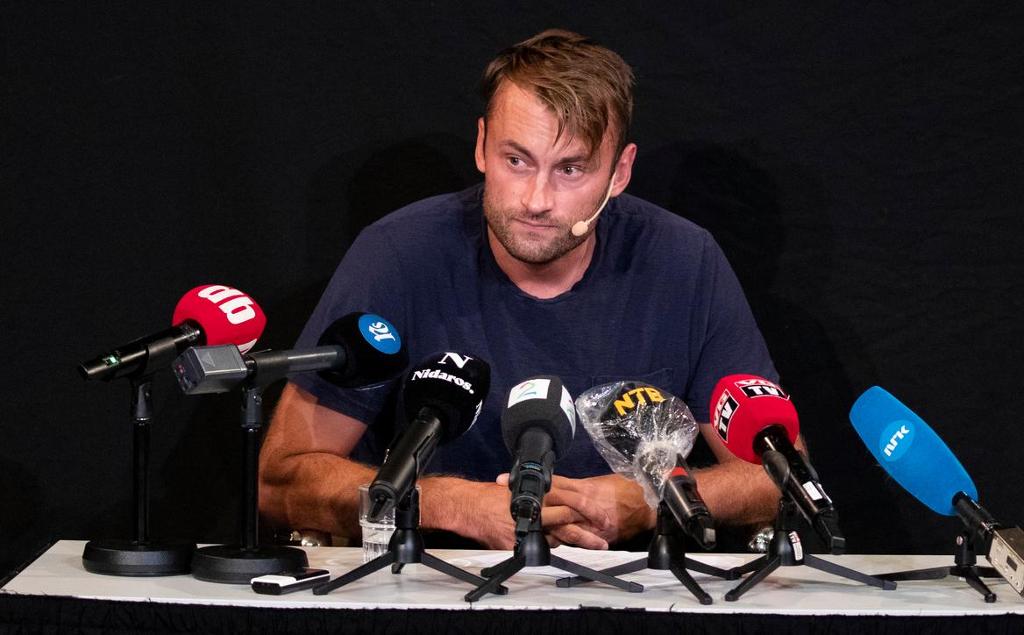 Petter Northug sitter bak en rad mikrofoner på en pressekonferanse. Foto.