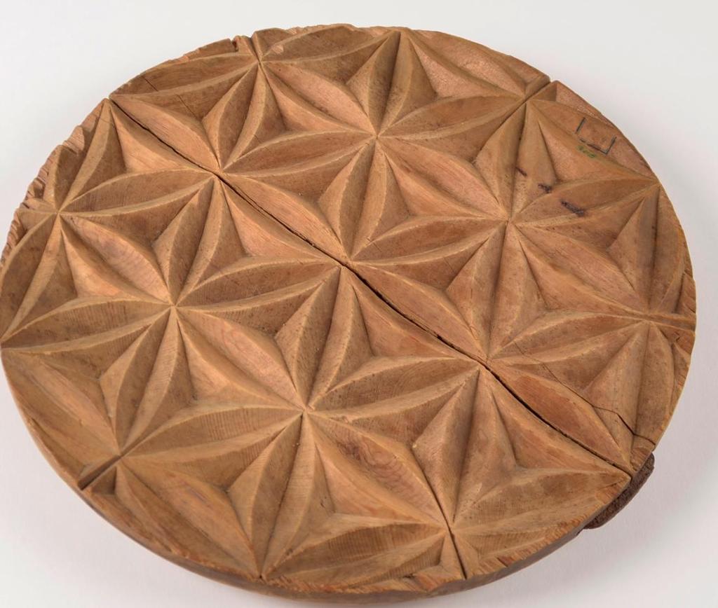 Sirkelformet treplate med geometrisk mønster utskåret. Foto. 