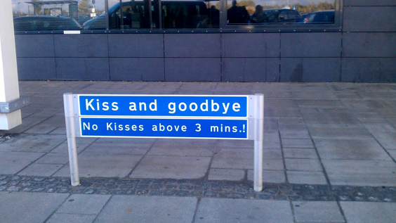 Bilde av et skilt med påskriften "Kiss and goodbye. No kisses above 3 mins.!" Foto. 