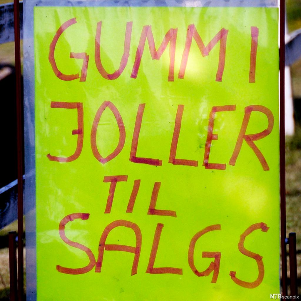 Plakat med orddelingsfeil: Gummi joller til salgs. Foto.