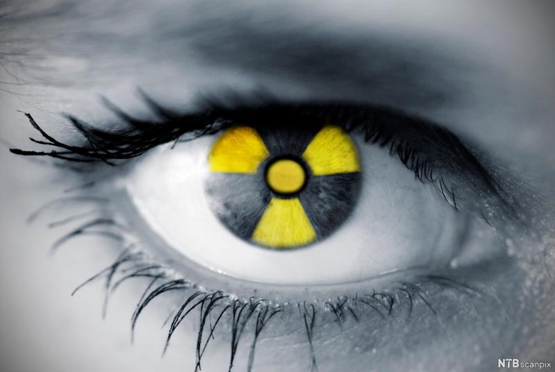 Nærbilde av et øye der pupillen ser ut som symbolet for radioaktivitet. Illustrasjon.