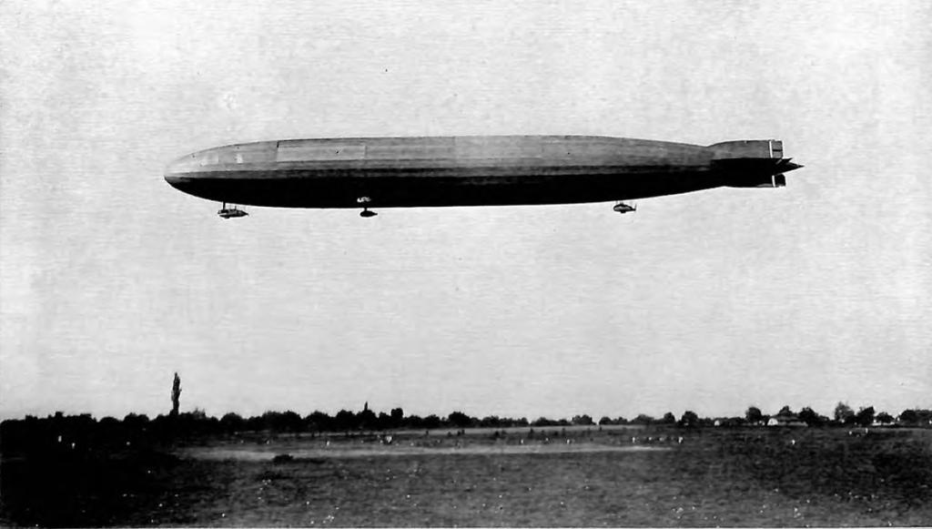 A German zeppelin in flight. It is an oblong, gas-filled baloon, mounted with propellers. Photo.